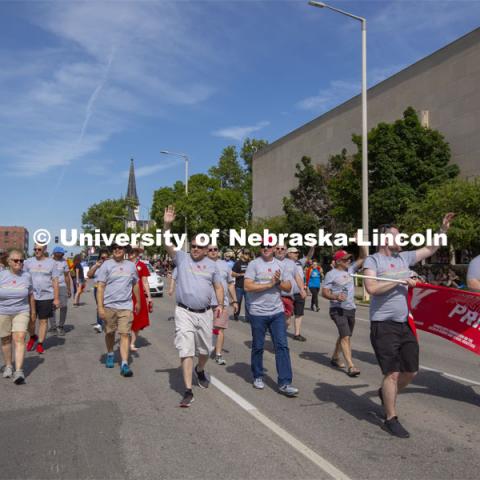 Corrie Svehla waves to the crowd as the Husker Pride entry walks down K Street during the June 19 parade. More than 20 members of the university community marched together during Lincoln's first Star City Pride parade. A number of campus administrators, including Chancellor Ronnie Green and his wife, Jane, participated in the walk around the Nebraska State Capitol. Star City Pride parade on June 19, 2021. Photo by Troy Fedderson / University Communication.